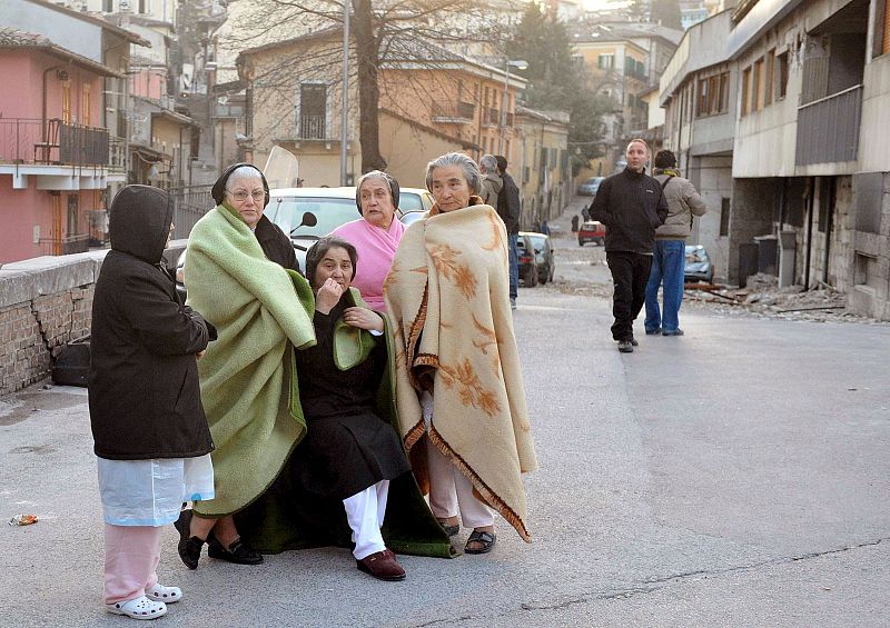 Un grupo de mujeres aguardan en la calle tras ser evacuadas de sus casas