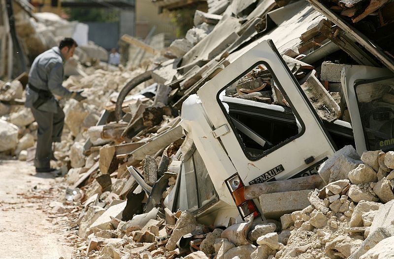 Un coche, cubierto de escombros en la villa de Onna, afectada por el terremoto ocurrido en el centro de Italia.