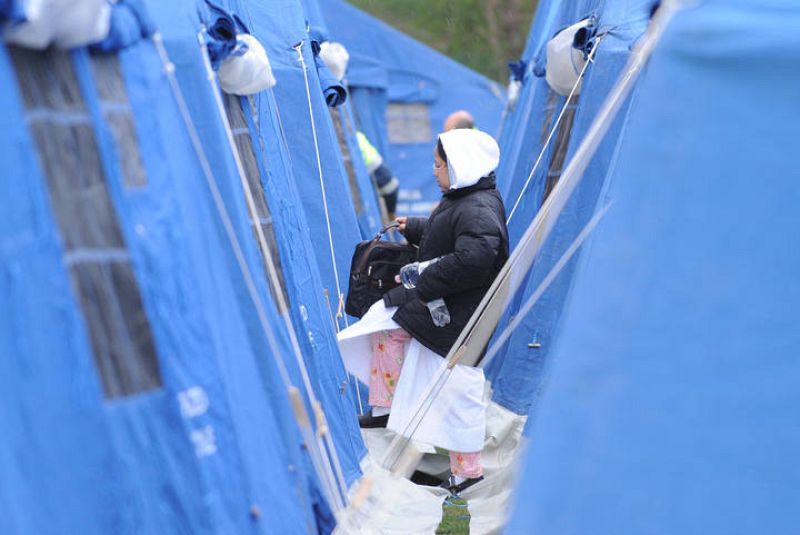Una monja anda entre las tiendas de campaña en L'Aquila.