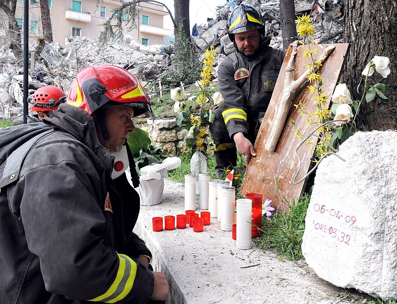 Un bombero reza junto a unos escombros tras el terremoto del pasado 2 de abril en L'Aquila.