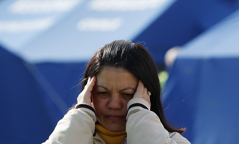 Una mujer se lamenta junto a las tiendas de campaña del campo de desplazados de L'Aquila.