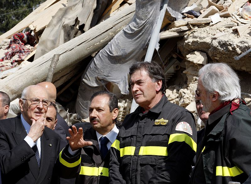 El presidente italiano, Giorgio Napolitano, escucha atentamente las explicaciones de los bomberos en Onna.