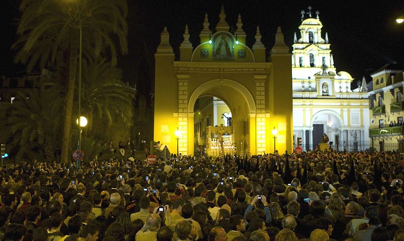 Cientos de miles de sevillanos y turistas acompañan el paso de la Virgen de la Macarena a su paso por el Arco de la Macarena.