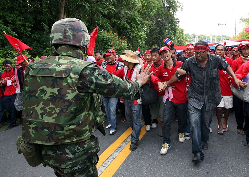 Un soldado trata de disuadir al grupo de protestantes que intentan avanzar para entrar en la sede de la cumbre.