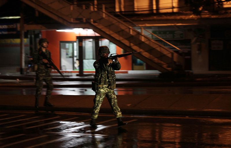 A soldier fires in the air as soldiers try to clear a main road blocked by supporters of ousted Thai PM Thaksin in Bangkok