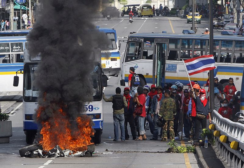 Los partidarios de Shinawatra queman neumáticos en sus protestas en Bangkok.