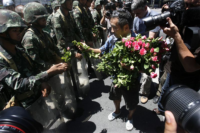 Un hombre pide que cese la violencia repartiendo rosas a los soldados en Bangkok