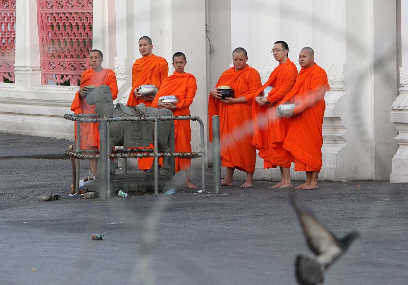 Monjes se alinean atrás de una barrera de alambre de púas cerca de la sede del Gobierno en Bangkok.