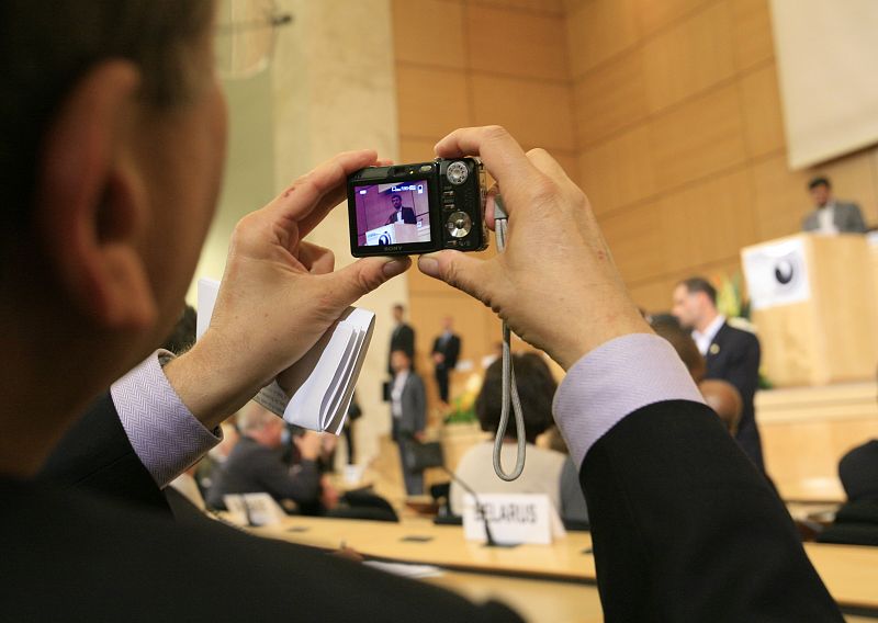 A delegate takes a picture as Iran's President Ahmadinejad addresses the High Level segment of the Durban Review Conference on racism at the United Nations European headquarters in Geneva