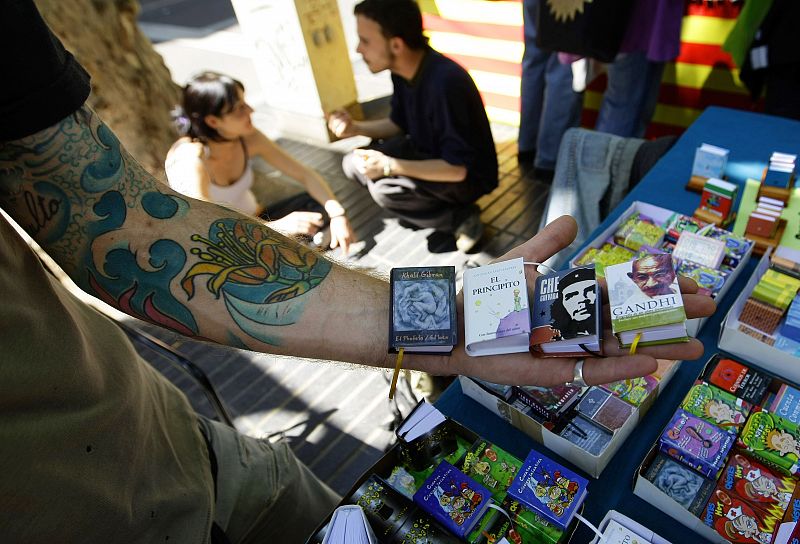Un vendedor de libros muestra sus mini-libros en un puesto de Las Ramblas de Barcelona.