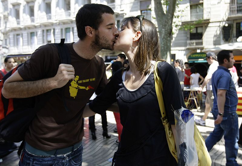 Una pareja se besa en Las Ramblas de Barcelona durante la celebración del día de San Jordi.