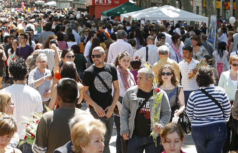 Numerosas personas pasean por las Ramblas de Barcelona durante la jornada festivo-literaria de Sant Jordi.