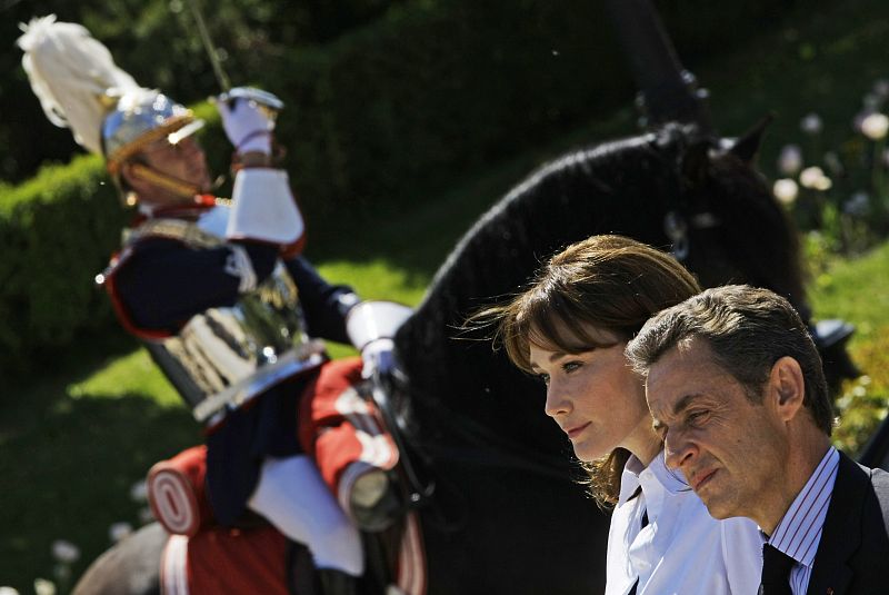 Sarkozy y Bruni asisten atentos a la ceremonia de bienvenida en el Palacio del Pardo.