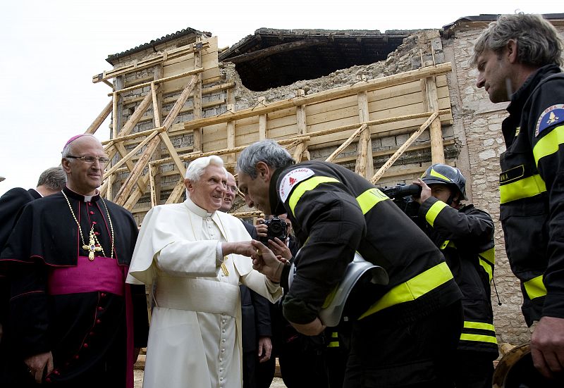 Pope Benedict XVI greets the firemen after visiting a little church in the destroyed village of Onna