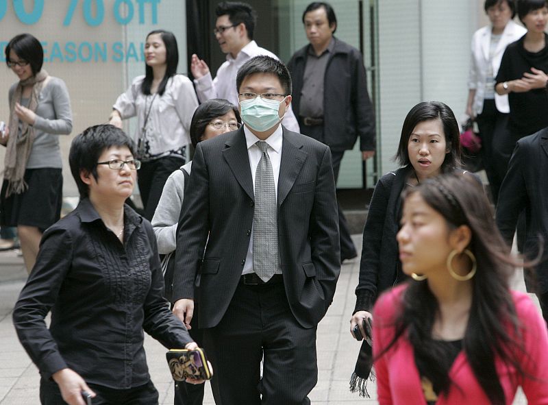 Un hombre camina con una máscara por el distrito central de Hong Kong, en China.