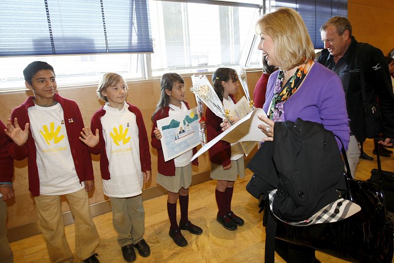 Miembros del COI que evalúa las candidaturas a los Juegos de 2016, saludan a unos niños que les dan la bienvenida a su llegada al aeropuerto de Barajas.