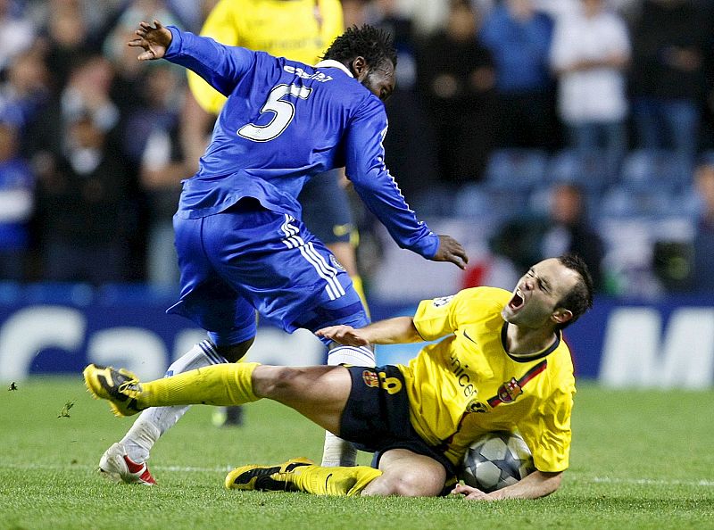 Iniesta cae al suelo ante el centrocampista ghanés del Chelsea, Michael Essien.