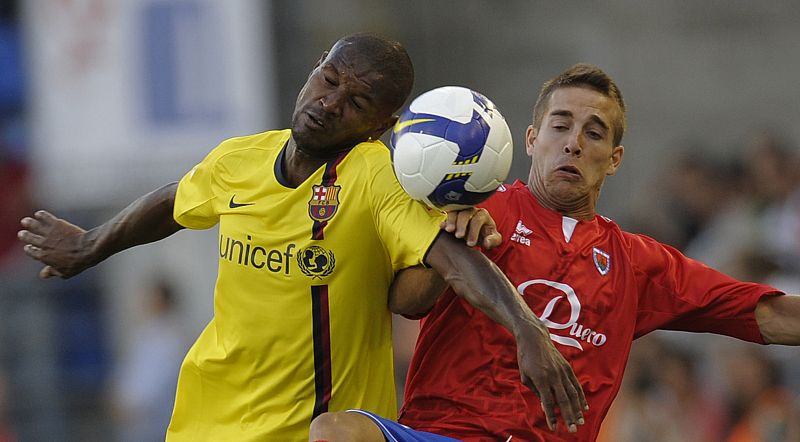 Barcelona's Abidal and Numancia's Anton fight for the ball during their Spanish First Division Soccer League match at Los Pajaritos stadium in Soria