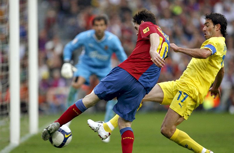 Lionel Messi chuta a portería con la oposición del defensa del Villarreal CF Javi Venta.