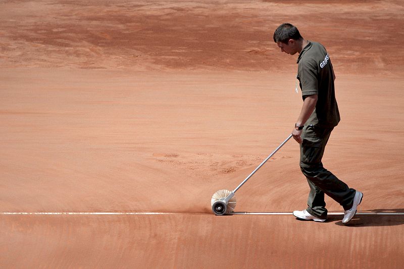 Un operario pinta una línea de la pista de la Caja Mágica.