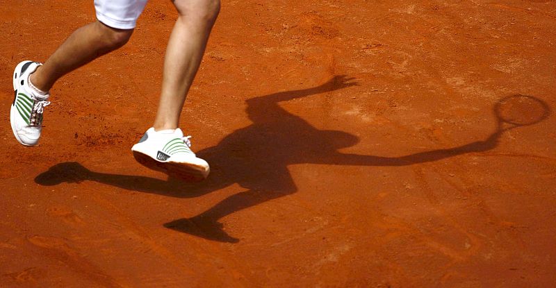 Imagen de la sombra del tenista estadounidense Mardy Fish mientras golpea la bola durante el partido contra el español Tommy Robredo.