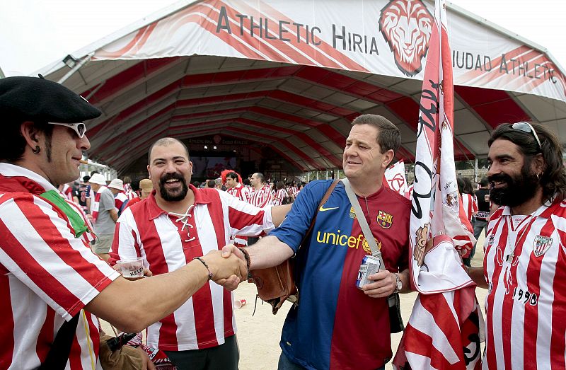 Aficionados del Athletic de Bilbao estrechan la mano de un seguidor del FC. Barcelona