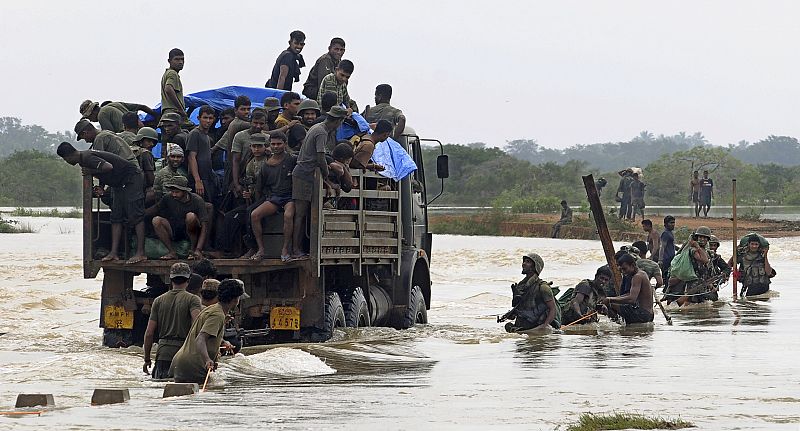 Soldiers cross a flooded road in Poonaryn