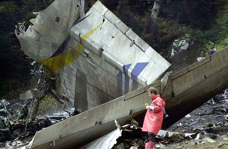 Un miembro del equipo de rescate camina junto a lo que ha quedado del fuselaje del Yak-42.