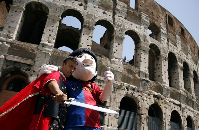 Dos aficionados del Barça, disfrazados de Messi y de un gladiador, posan juntos delante del Coliseo