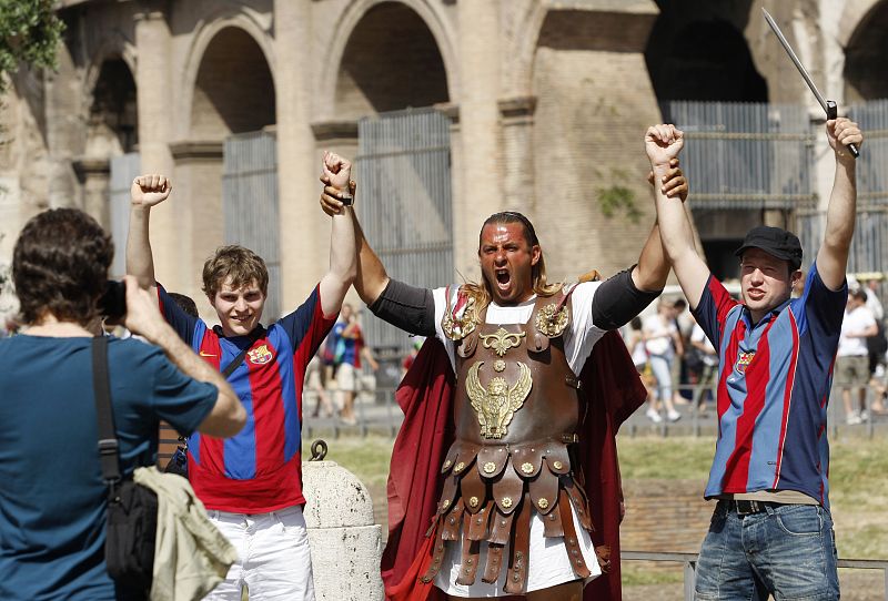 Aficionados del Barcelona posan con un animado centurión romano frente al Coliseo romano