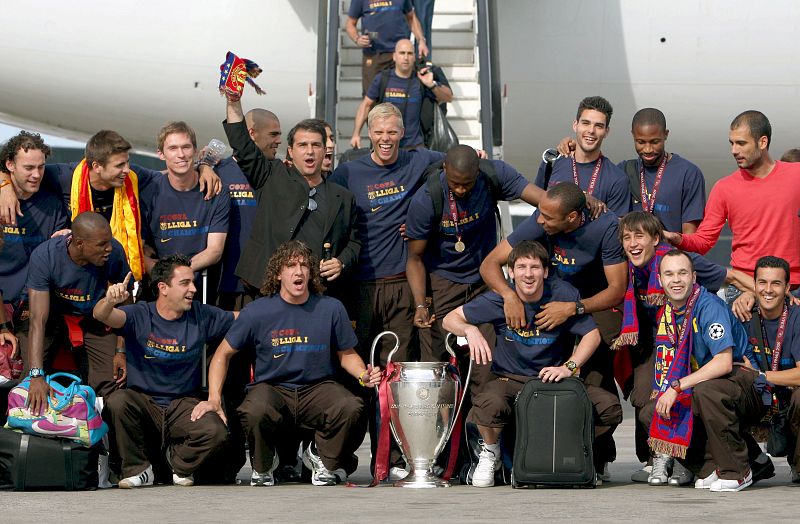 Jugadores y directivos del F C Barcelona posan con la copa a su llegada al aeropuerto de El Prat.