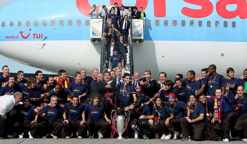 Jugadores y directivos del FC Barcelona posan con la copa a su llegada al aeropuerto de El Prat.