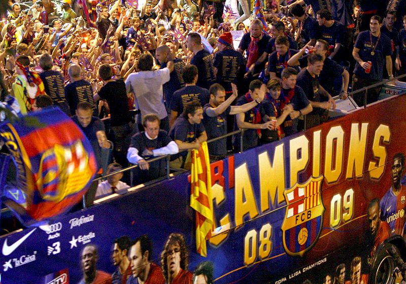 El entrenador del F.C.. Barcelona, Pep Guardiola, saluda al público durante la celebración.