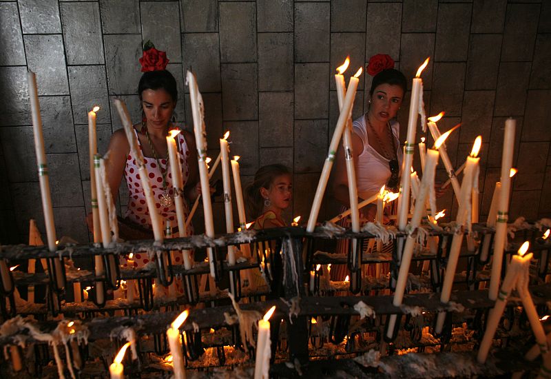 Pilgrims light candles in the shrine of El Rocio in Almonte, in the province of Huelva