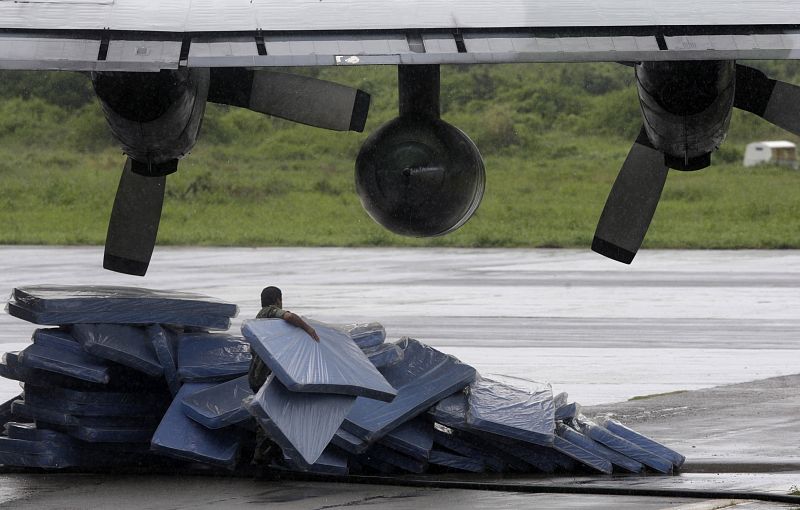 A member of Brazilian Air Force arranges mattresses under the wing of a Hercules plane at a base in Fernando de Noronha island