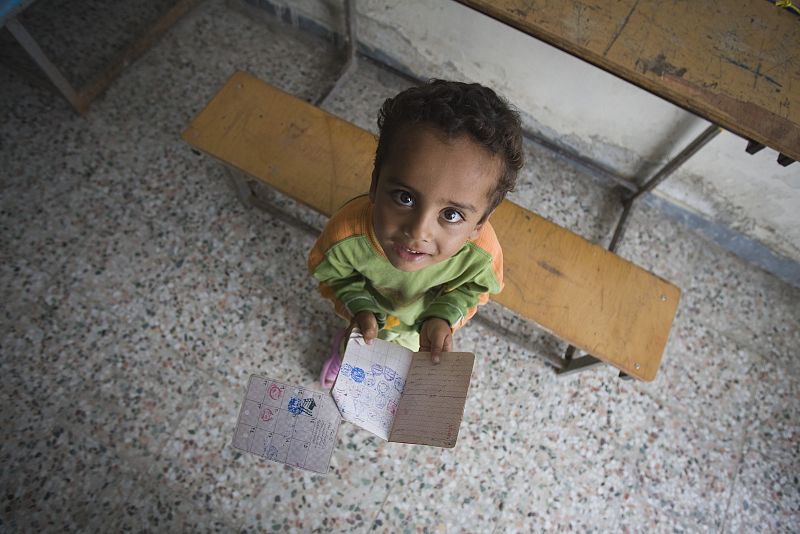 Un chico, con los documentos de su padre antes de la votación en el pueblo iraní de Zabolmahalleh.