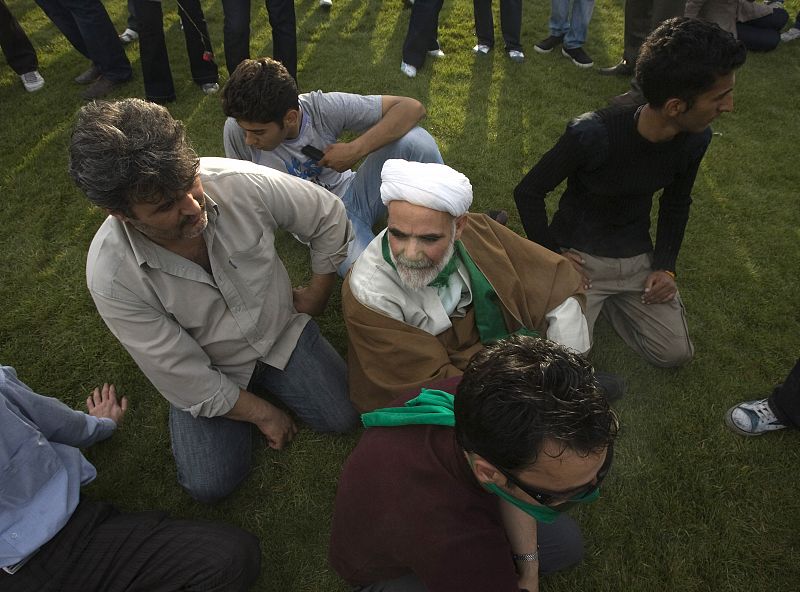 Un clérigo se sienta en la plaza de Azadi, para asistir a una reunión en apoyo a Mousavi.