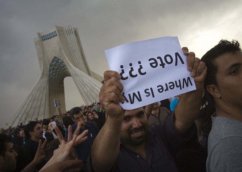 Un partidario de Mirhossein Mousavi sostiene un cartel al revés.