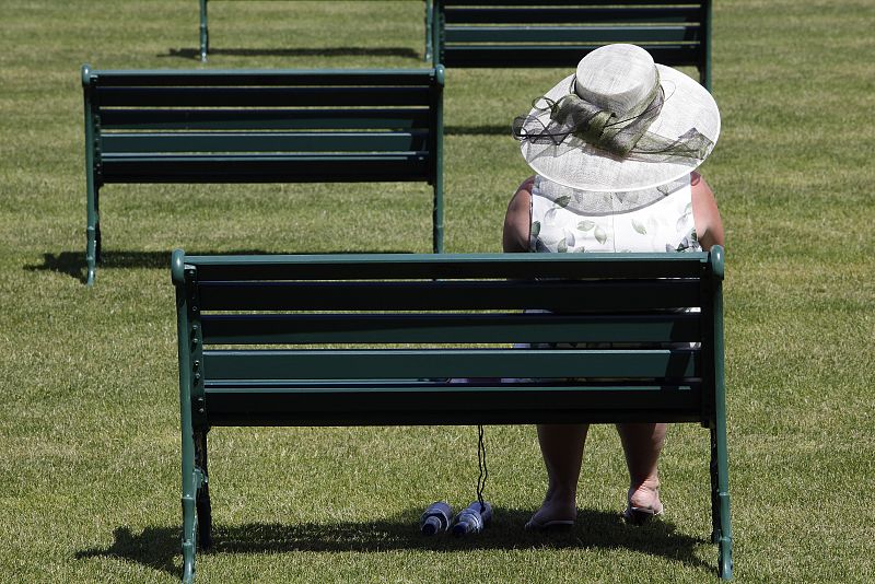 Una aficionada se sienta en un banco durante el primer día de competición en el Royal Ascot.