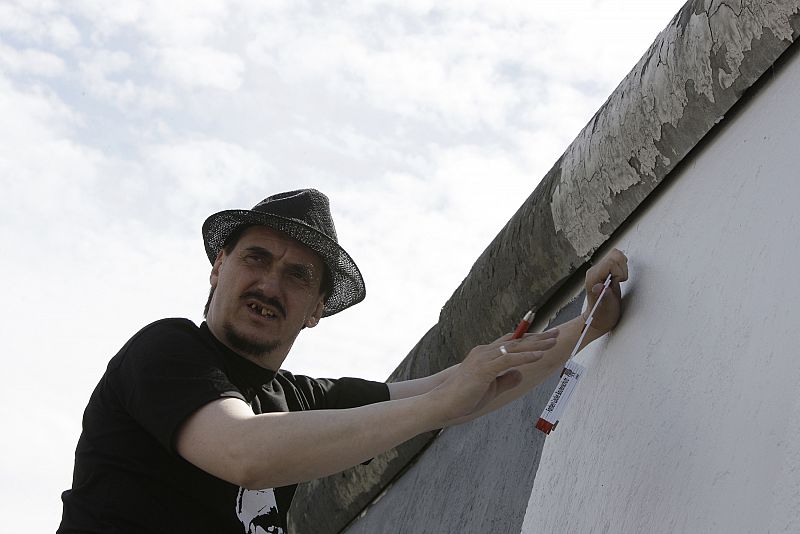 Russian artist Dmitry Vrubel starts restoration work on mural at East Side Gallery in Berlin
