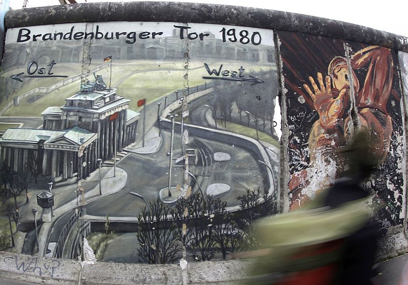 Tourist walks along the 'East Side Gallery' in Berlin