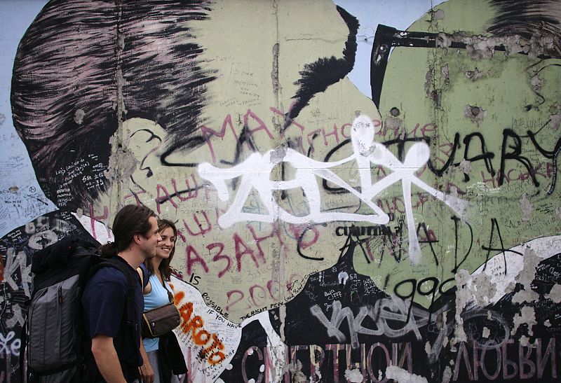 Tourists walk past the East Side Gallery in Berlin