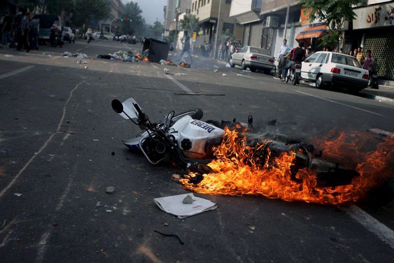 Una moto de policía ardiendo durante una protesta por las calles de Teherán, tras los enfrentamientos entre opositores y la Policía.