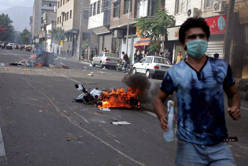 Iraníes se enfrentan a la policía durante una protesta por las calles de Teherán, Irán.