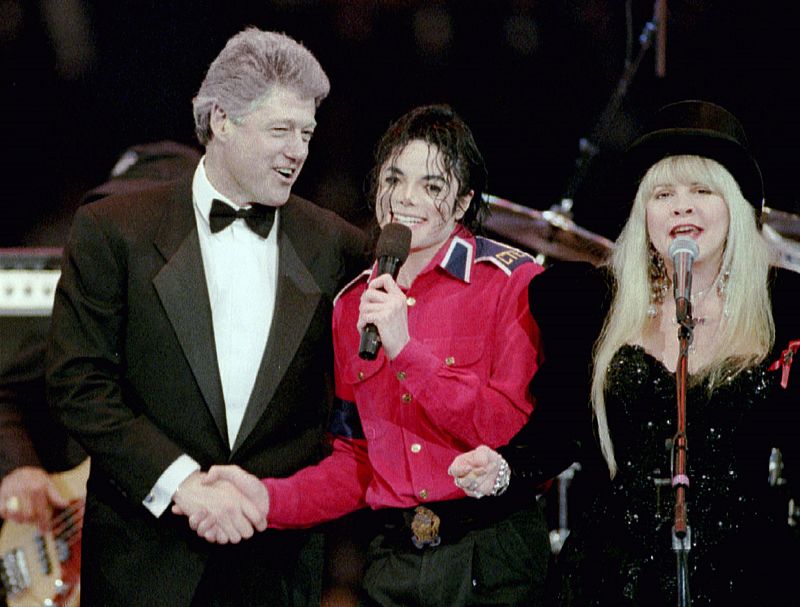 Jackson estrecha la mano de Bill Clinton mientras Stevie Nicks, de Fleetwood Mac, canta sobre el escenario. Washington, 1993.