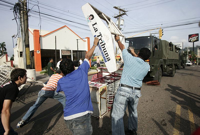 People block the street to prevent military trucks passing in Tegucigalpa