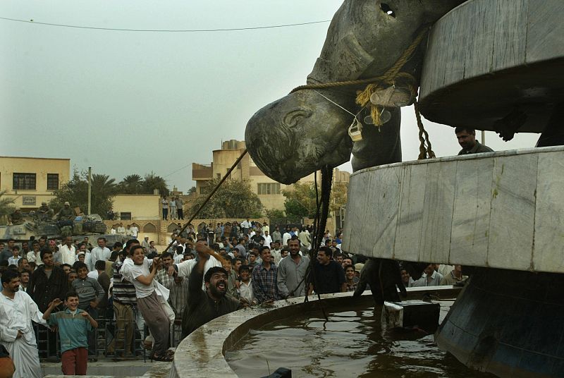 IRAQI CITIZENS HIT A PULLED DOWN A STATUE OF SADAM IN THE TOWN OF