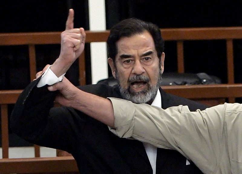 Former Iraqi President Saddam Hussein yells in court as he receives verdict, as bailiff attempts to silence him, during trial in Baghdad