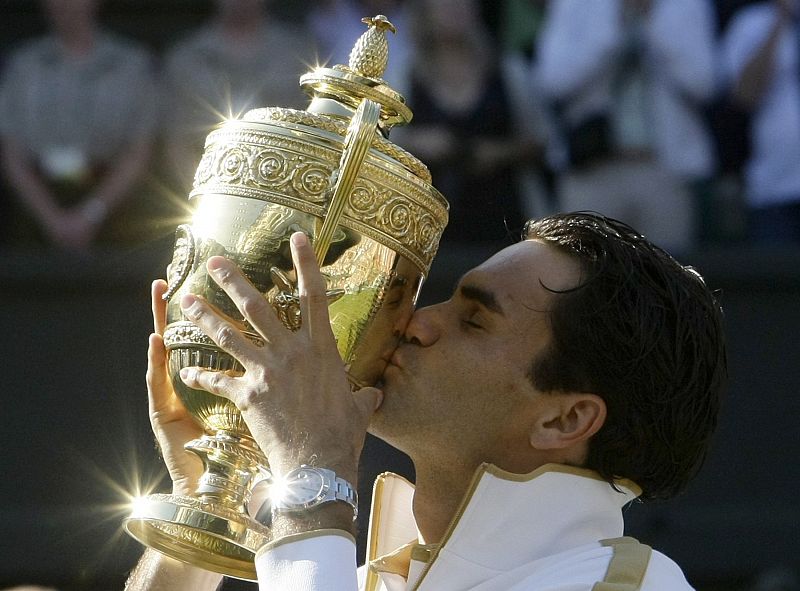 Federer besa su trofeo de Wimbledon, conseguido el 5 de julio de 2009, el sexto de su carrera y 15º de su palmarés