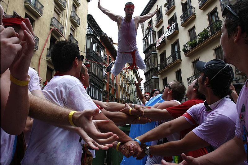 Varias personas alzan a un chico
